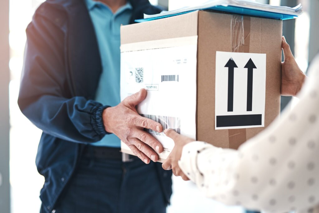 delivered right on time at your residence. an unrecognizable delivery man handing a package to a female customer.